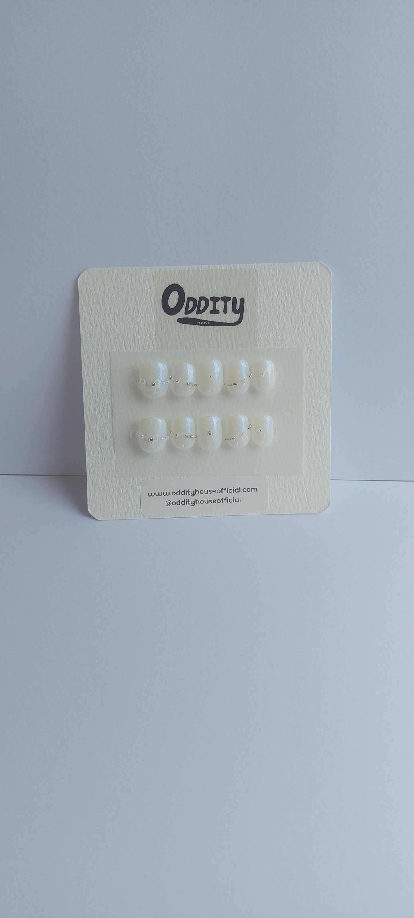 Rectangular card with small white objects on a light gray background